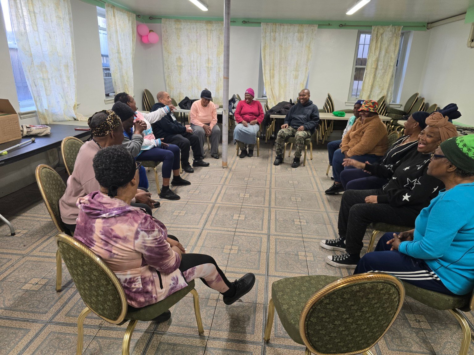 Older adults seated in a circle sharing conversation and laughter